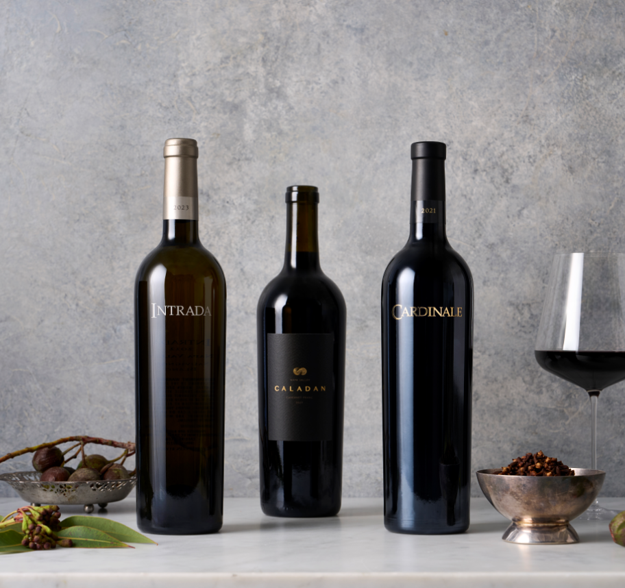 Two Bottles of Cardinale wine with a wine glass next to them